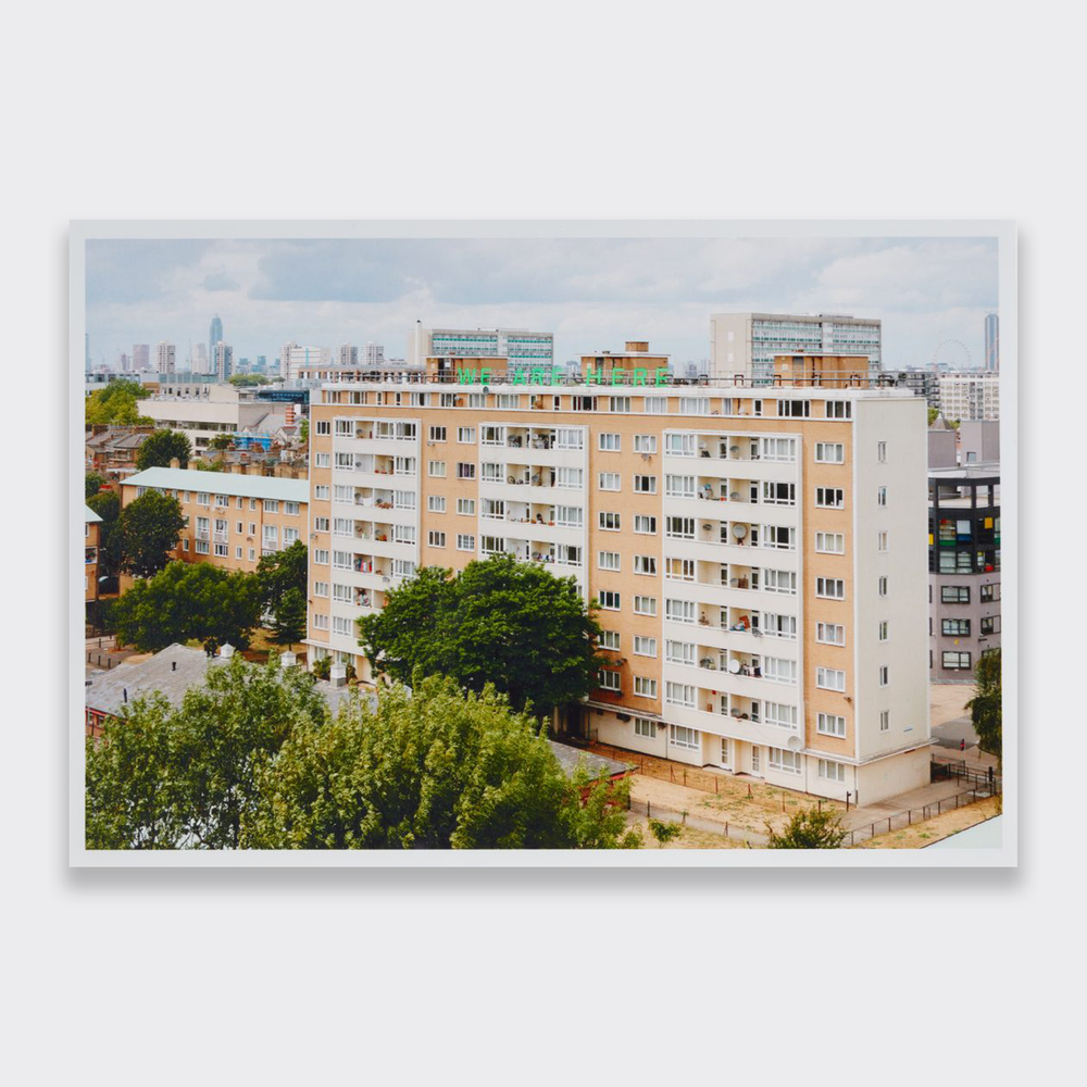 A photograph of a block of flats in London. This limited edition art work is titled We Are Here by artist Jessie Brennan.