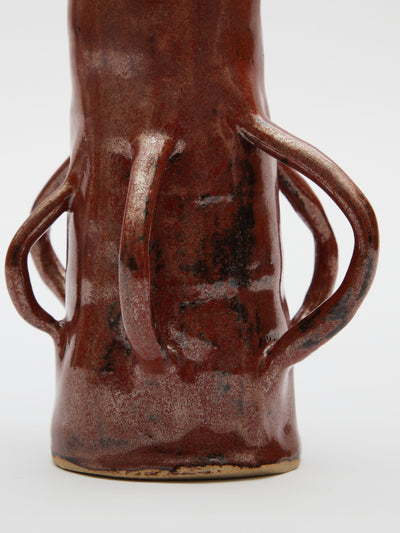 A tall skinny brown vase with handles made by independent artist Gwynnie Gaunt