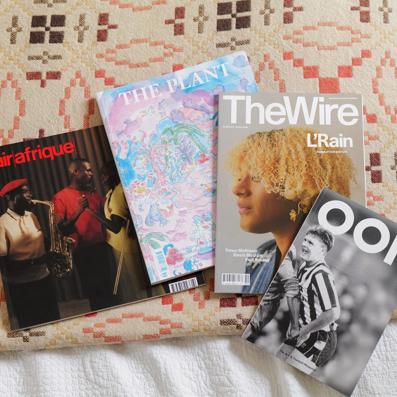 Magazines lie on a bed beside each other. They include air afrique, The Plant, The Wire and OOF.