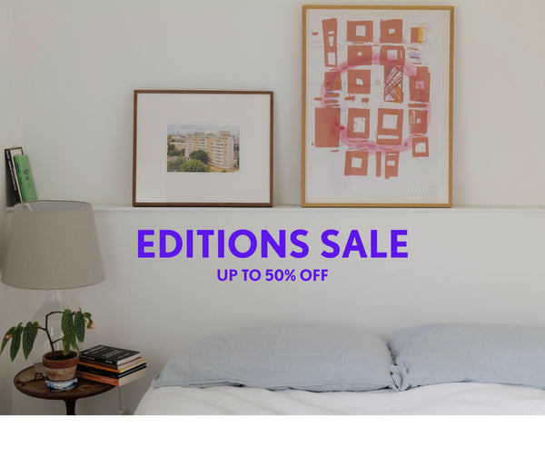 Bedroom with framed artwork and a 'Editions Sale' text overlay
