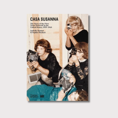 The book is called 'Casa Susanna: The Story of the First Trans Network in the United States, 1959-1968' by Casa' by Isabelle Bonnet & Sophie Hackett. It has an image of four transgender women holding cameras on the cover page of the book on a white background. 