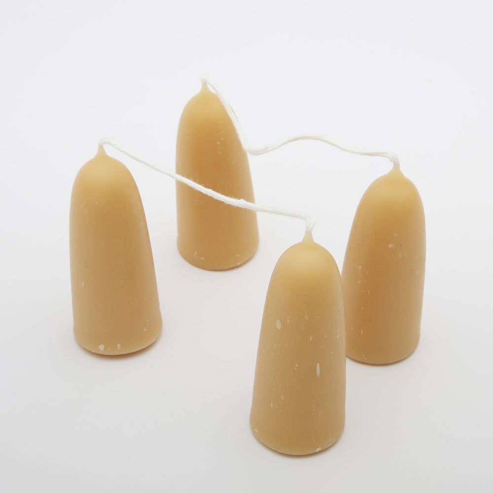 Four short yellow beeswax candles made by Moorlands