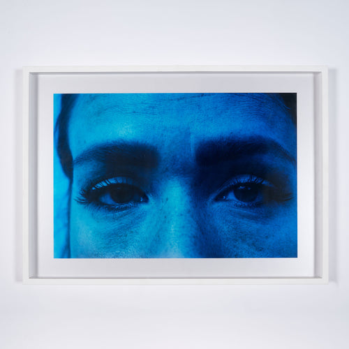 A bright blue photograph of a persons eyes and eyebrows by artist Basim Magdy
