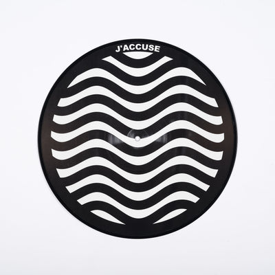 A vinyl disc with a wavy white and black pattern with the word 'J'accuse' on it.