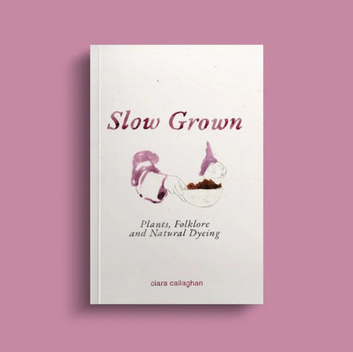 A book titled 'Slow Grown' by Ciara Callaghan on a pink background. There is this purple and brown watercolour painting design of hands holding a bowl.