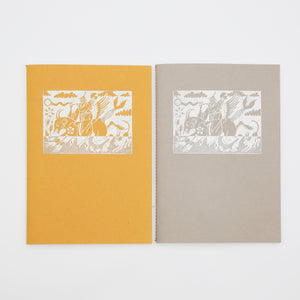 Two notebooks produced by PageMasters. Both sketchbooks have a riso print image on the front of a person riding a horse. One notebook is yellow, the other is grey. 