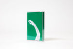 A green cassette tape cover. The cover image is of a white arm reaching out. The tape is a limited edition by artist Abbas Zahedi.