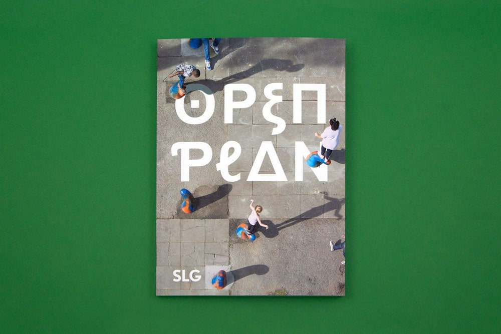 A book on a bright green background. The book is titled Open Plan and was published by the South London Gallery. The cover of the book has a photograph of children playing in a concrete playground. 